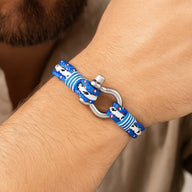 Bracelet nautique triple cordon bleu et blanc en nylon avec mousqueton en acier inoxydable sur poignet.