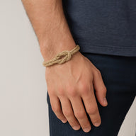 Bracelet en corde beige noué avec fermoir aimanté porté au poignet, style naturel.