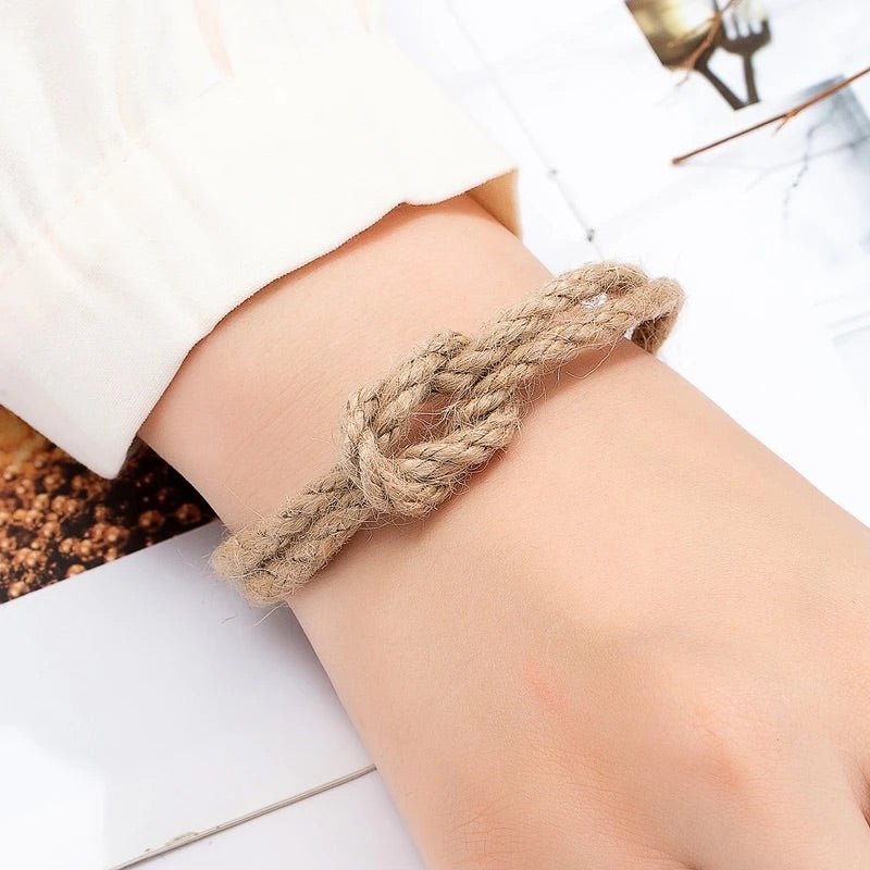 Bracelet beige en corde tressée avec nœud et fermoir aimanté, style naturel, porté au poignet.