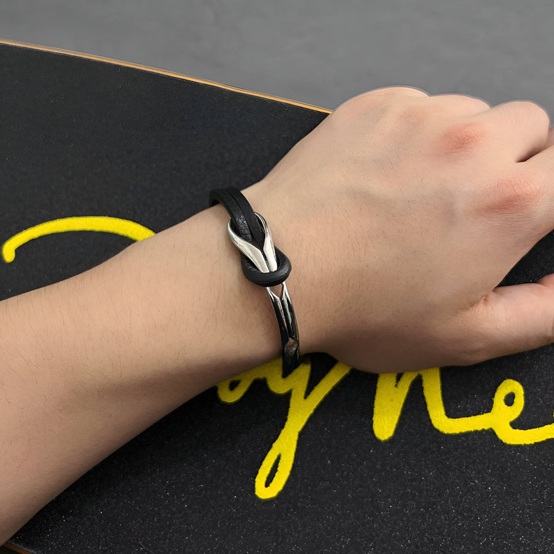 Bracelet homme noir en cuir avec nœud et détail en titane brossé élégant.