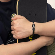 Bracelet homme noir en cuir avec nœud en titane mat, style minimaliste et moderne.