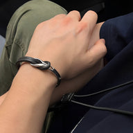 Bracelet homme en cuir noir avec nœud et détail titane brossé moderne.