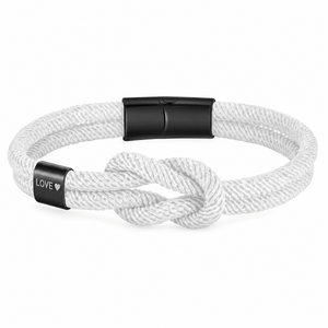 Bracelet Nono Blanc et noir, embout métallique gravé LOVE ♥ près du nœud marin, posé de face sur fond blanc