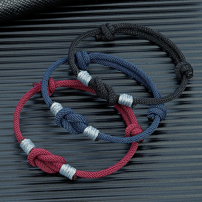 Lot de trois bracelets nœud marin en nylon ajustables bleu marine, noir et bordeaux avec finitions argentées.