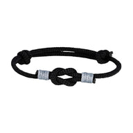 Bracelet nœud marin en nylon noir avec ajustement coulissant et détails gris clair.