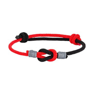 Bracelet nœud marin ajustable en nylon rouge et noir avec détails gris, style coulissant.
