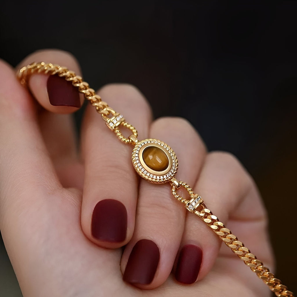 Bracelet femme en acier inoxydable doré avec pierre œil de tigre ovale sertie de motifs raffinés.