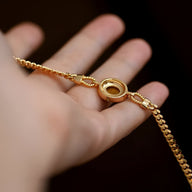 Bracelet femme en acier inoxydable doré avec pendentif rond œil de tigre et chaîne maille gourmette.