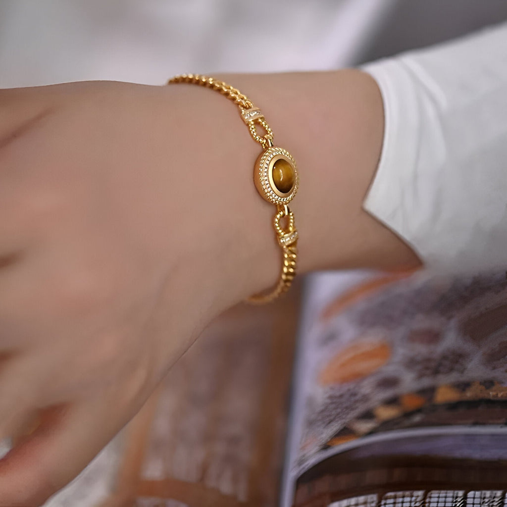 Bracelet or en acier inoxydable avec pierre oeil de tigre ovale, chaîne fine à maillons ajustables.