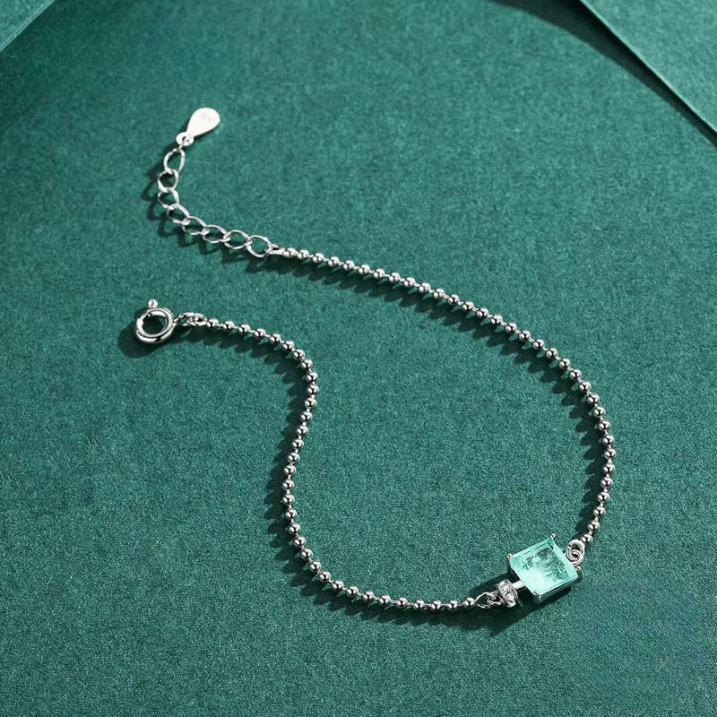 Bracelet en argent sterling avec pierre de tourmaline bleue carrée et chaîne fine.
