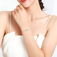 Bracelet fin en argent sterling avec pierre de tourmaline bleue portée au poignet féminin.