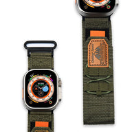 Bracelet nylon kaki ajustable à velcro pour Apple Watch avec étiquette orange et noire.