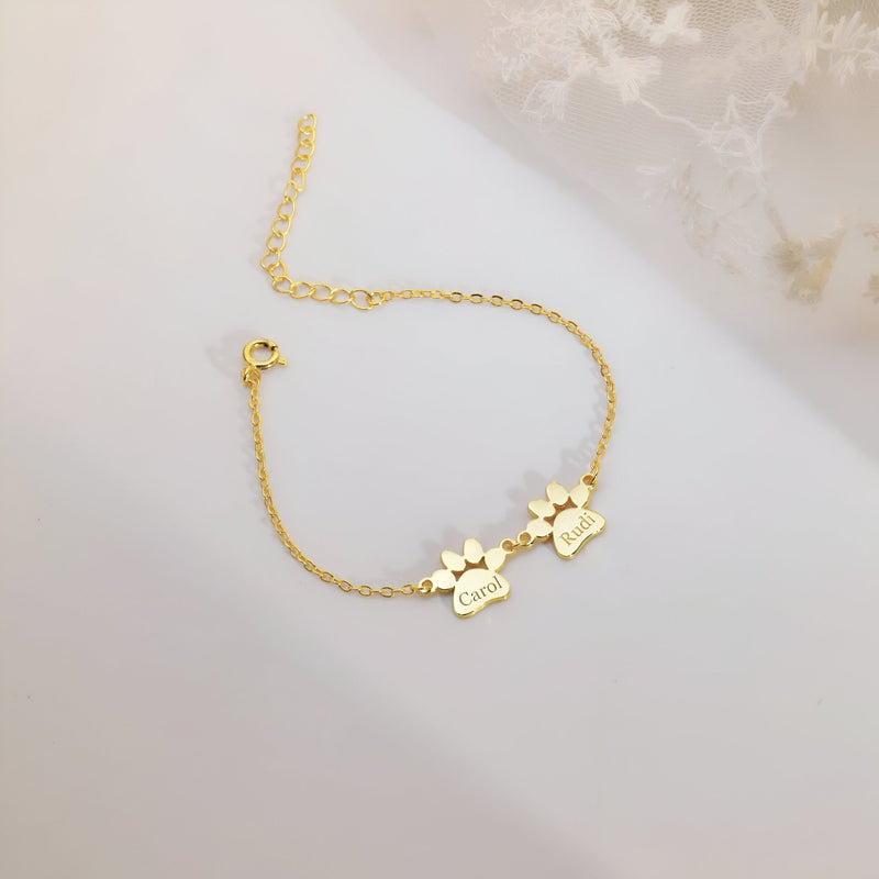 Bracelet en acier inoxydable doré avec deux pendentifs pattes personnalisés gravés.
