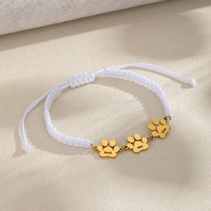 Bracelet en nylon blanc avec trois pampilles pattes dorées en acier inoxydable, style Médor.