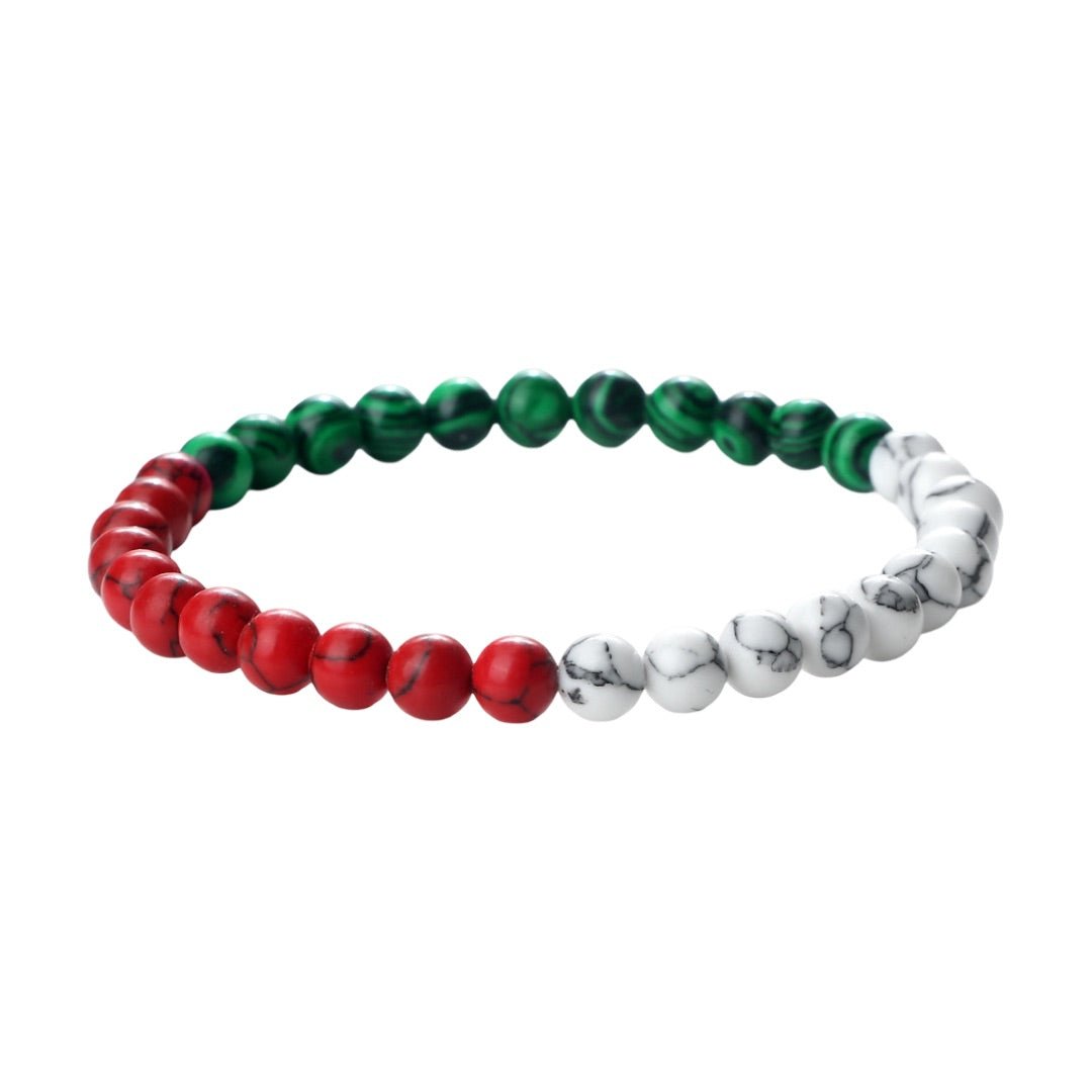 Bracelet perlé en pierres d'imitation rouges, vertes et blanches sur cordon noir souple, style graphique.