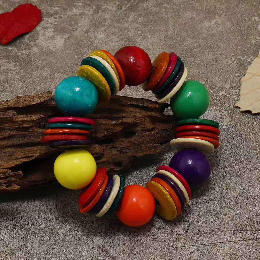 Bracelet perlé multicolore en bois naturel avec grosses perles rondes et disques colorés.