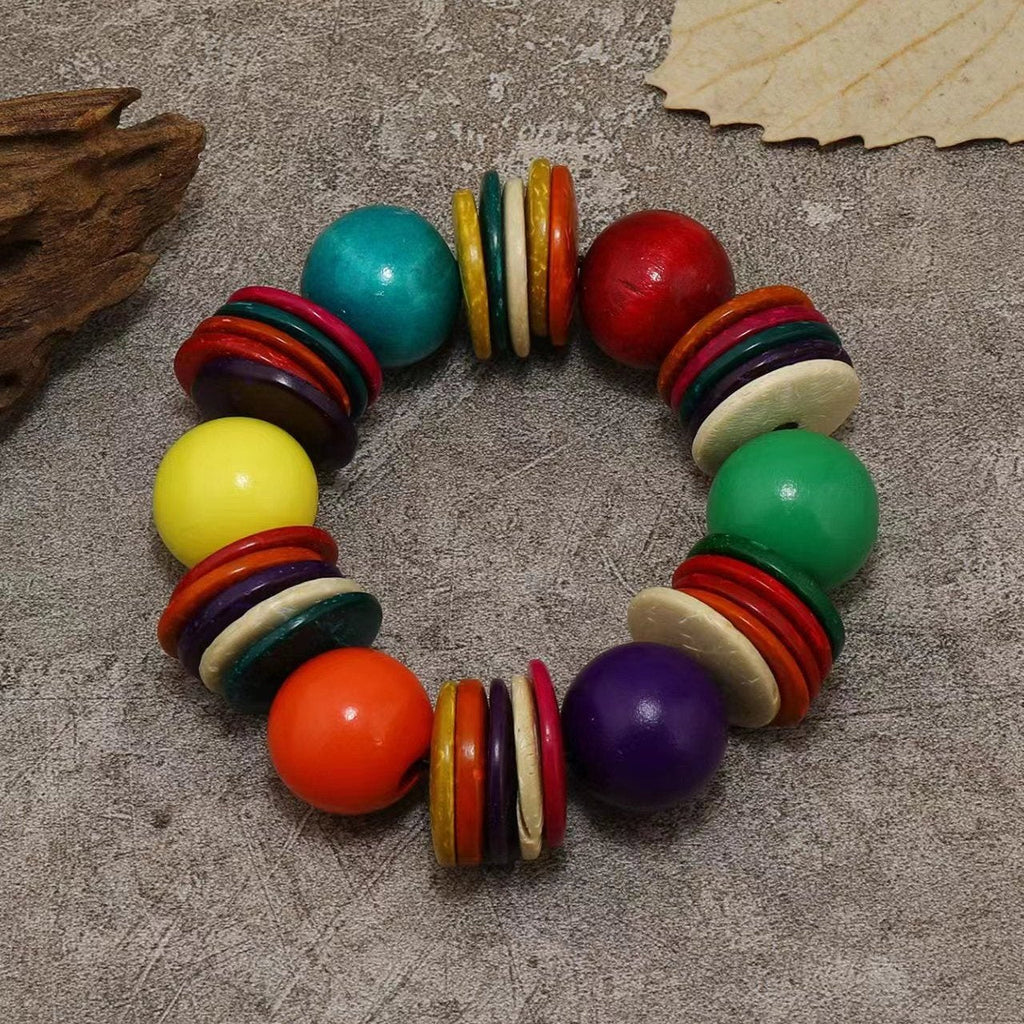 Bracelet perlé rond en bois naturel multicolore avec grosses boules et anneaux plats colorés.