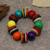 Bracelet perlé rond en bois naturel multicolore avec grosses boules et anneaux plats colorés.