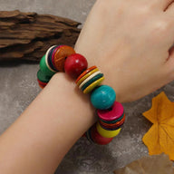 Bracelet perlé en bois multicolore, billes rondes et disques plats, style bohème pour femme.