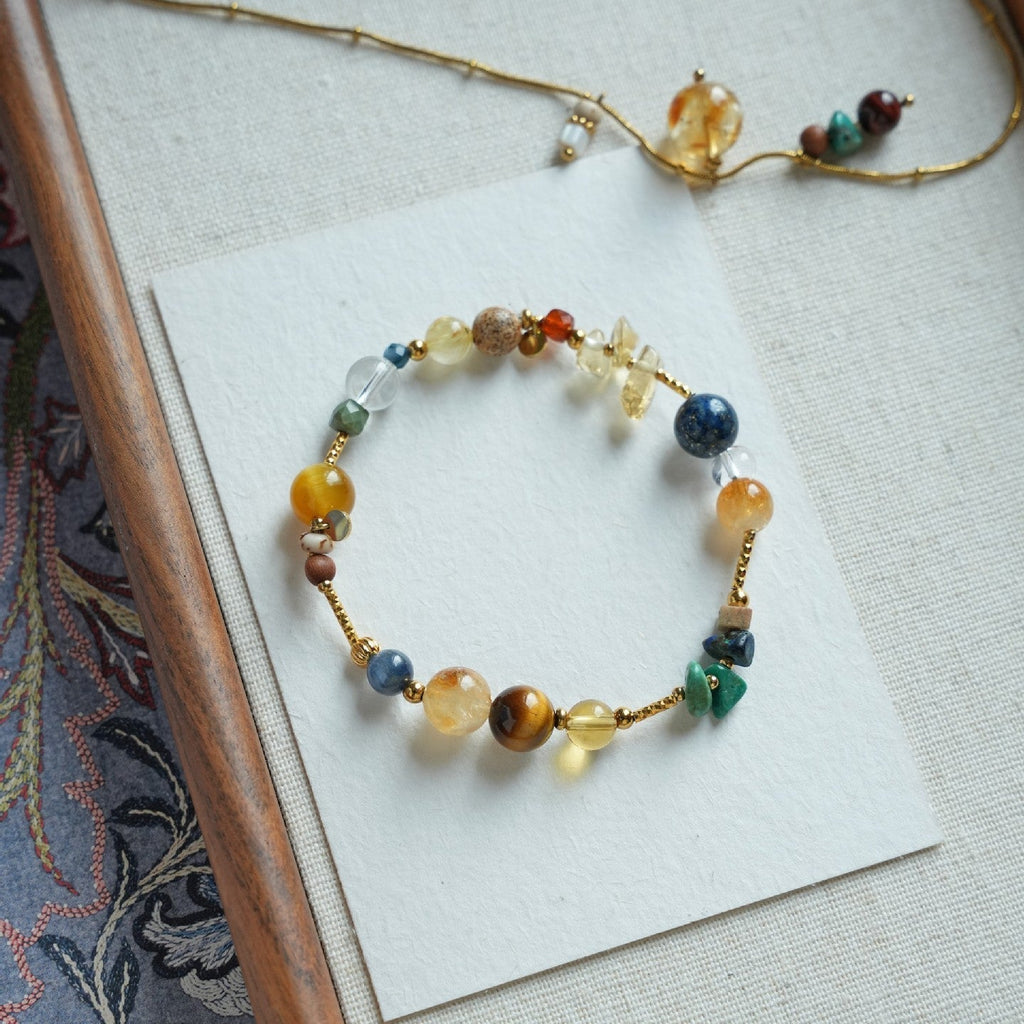 Bracelet perlé multicolore avec pierres naturelles rondes et éclats dorés, style élégant et raffiné.