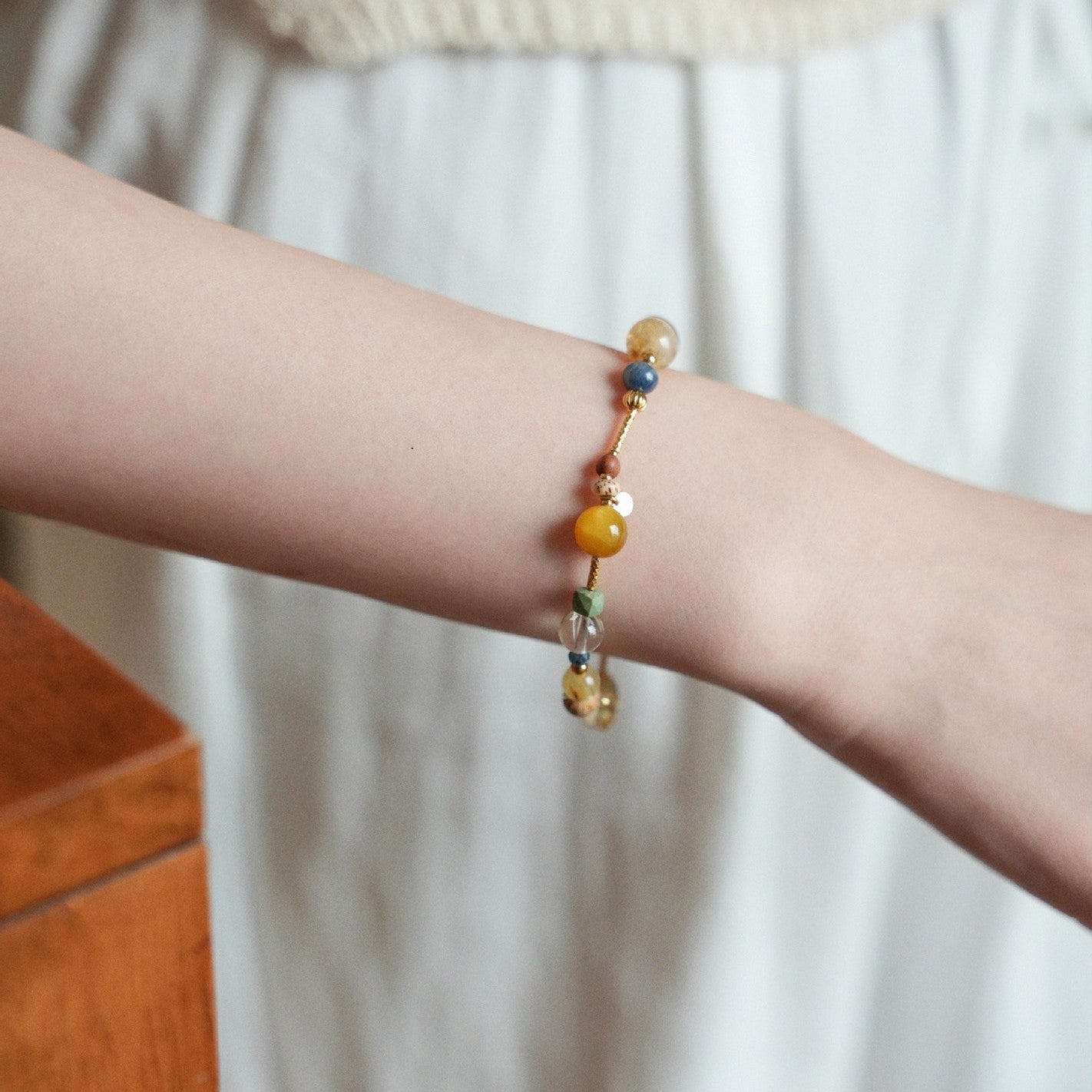 Bracelet perlé multicolore avec pierres naturelles rondes, détails dorés et lien fin ajustable, style élégant et délicat.