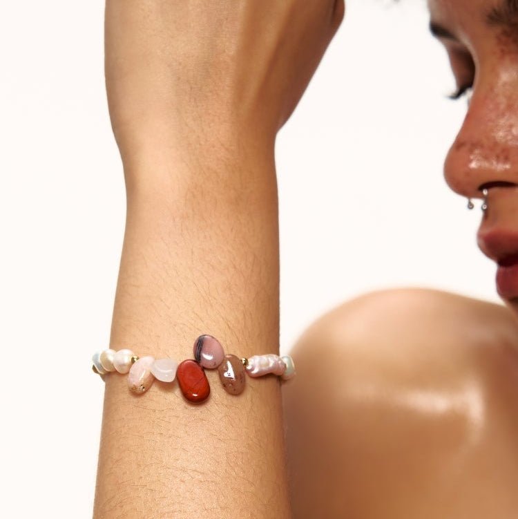 Bracelet ajustable en perles baroques blanches avec pendentifs pierres naturelles multicolores et fermoir doré.