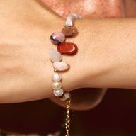 Bracelet fin avec perles baroques blanches et pierres naturelles ovales multicolores, fermoir doré ajustable.