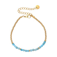 Bracelet fin en perles bleues naturelles et perles dorées, chaîne ajustable avec fermoir mousqueton doré.