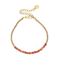 Bracelet fin en perles naturelles rouges et petites perles dorées, fermoir mousqueton doré, style rétro chic.