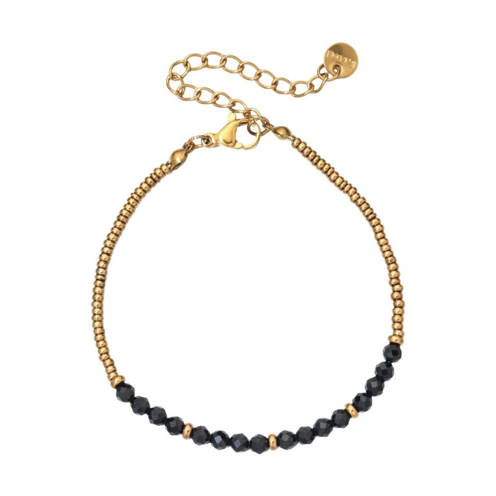 Bracelet fin en perles noires facettées et petites perles dorées, fermoir mousqueton doré en métal, style rétro chic.