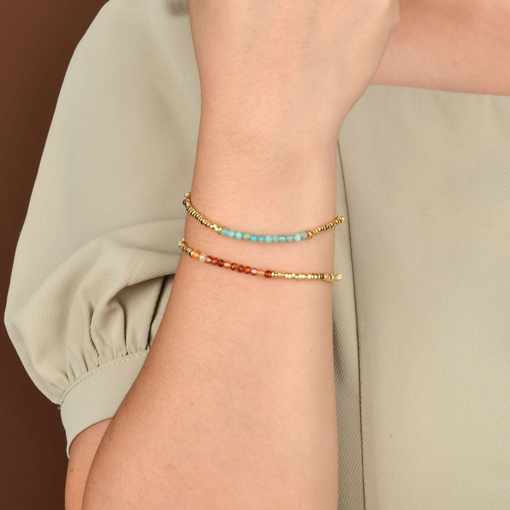 Bracelet fin en perles turquoise, blanches et dorées avec fermoir mousqueton, style rétro chic.