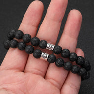 Bracelet élastique perles noires pierre de lave avec boutons argentés gravés symboles astrologiques zodiaque.