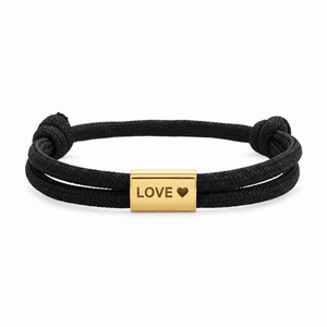 Bracelet Veyron Noir et or, plaque centrale gravée LOVE ♥, posé de face sur fond blanc