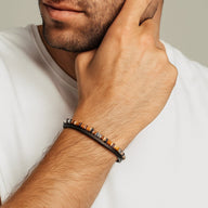 Bracelet masculin en cuir noir avec pierres naturelles marron et perles métalliques argentées, fermoir sécurisé.