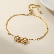 Bracelet personnalisé doré en acier inoxydable avec pendentifs pattes entrelacées et chaîne réglable.