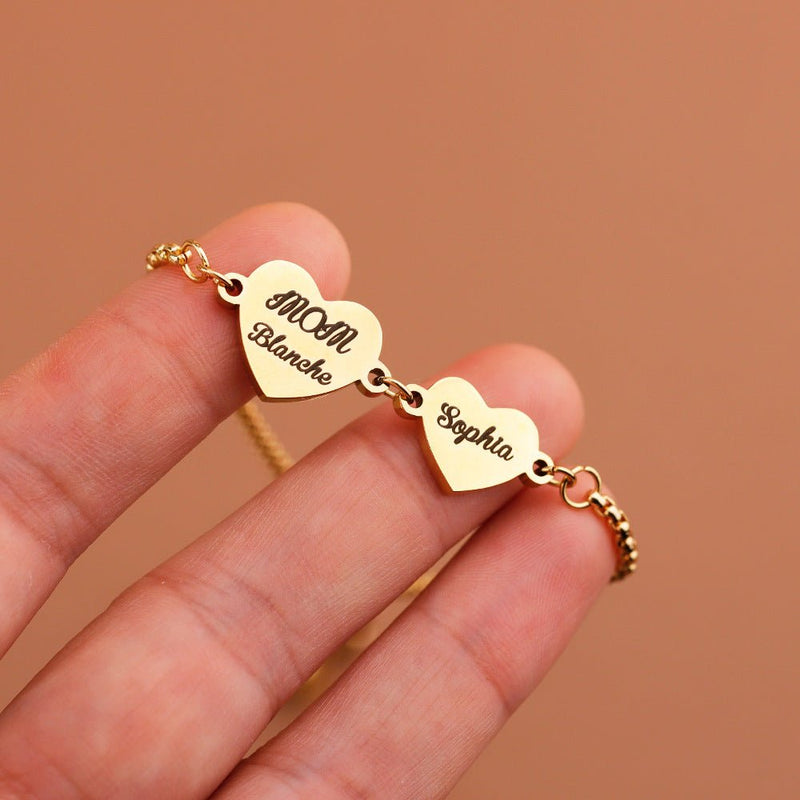 Bracelet doré ajustable avec deux pendentifs cœurs gravés « Mom Blanche » et « Sophia » en acier inoxydable.