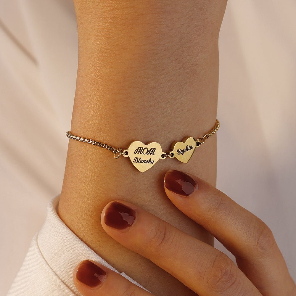 Bracelet fin en acier inoxydable avec trois cœurs gravés de prénoms, chaîne ajustable argentée.