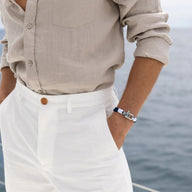 Bracelet double cordon bleu avec mousqueton argenté, porté homme, style marin chic.