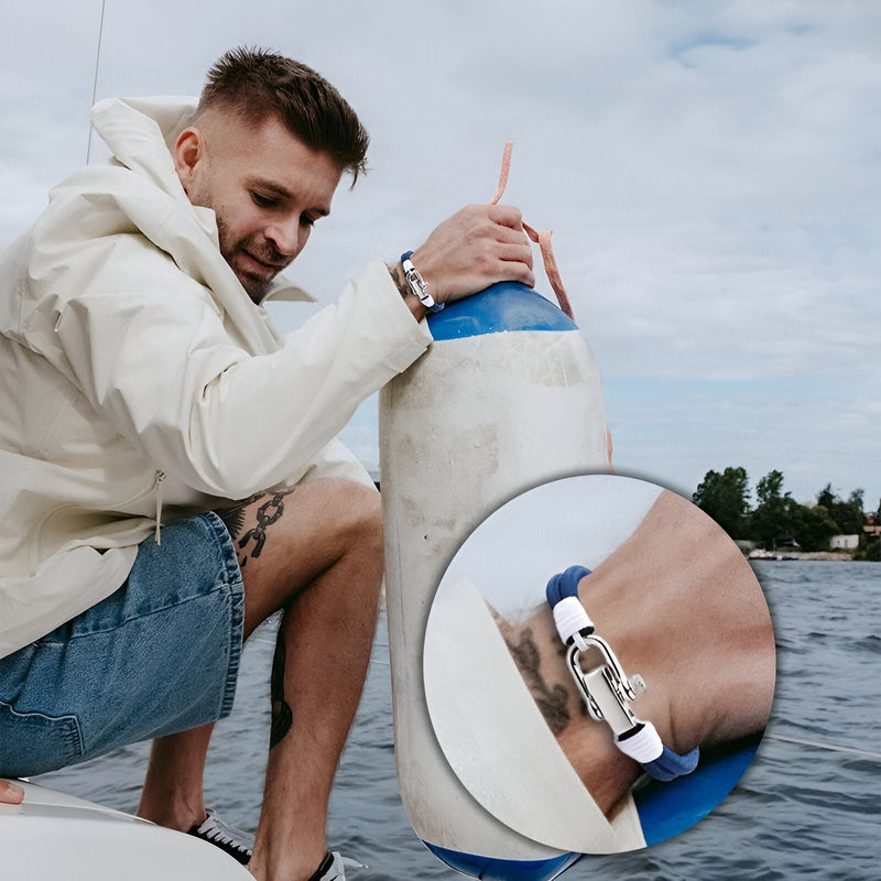 Bracelet pour homme en double cordon bleu avec fermoir mousqueton en métal argenté porté au poignet.