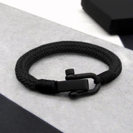 Bracelet noir pour homme en corde tressée avec fermoir mousqueton mat, style minimaliste.