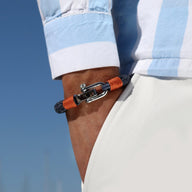 Bracelet homme bleu marine en cordon avec mousqueton argenté et détail cuir orange.