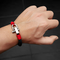 Bracelet homme noir et rouge avec mousqueton en métal argenté, style robuste et moderne.