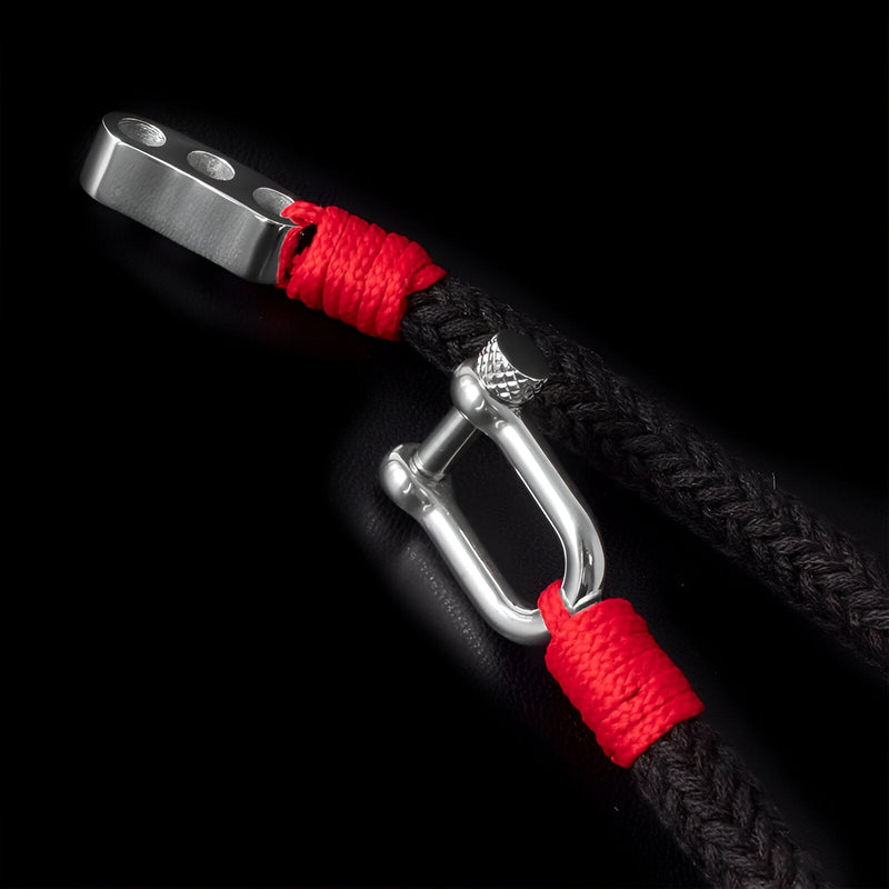 Bracelet homme noir tressé avec attaché mousqueton métal argenté et corde rouge.