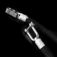 Bracelet homme en corde noire tressée avec mousqueton et détails de fils blancs.