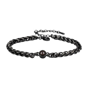 Bracelet maille tressée en acier inoxydable noir avec perle centrale brillante et fermoir réglable.