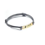 Bracelet cordon gris avec plaque acier inoxydable dorée gravée code Spotify noir.
