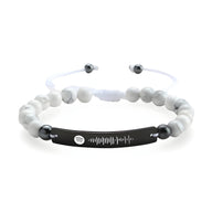Bracelet personnalisé Spotify en pierres naturelles blanches avec plaque noire gravée et cordon ajustable blanc.