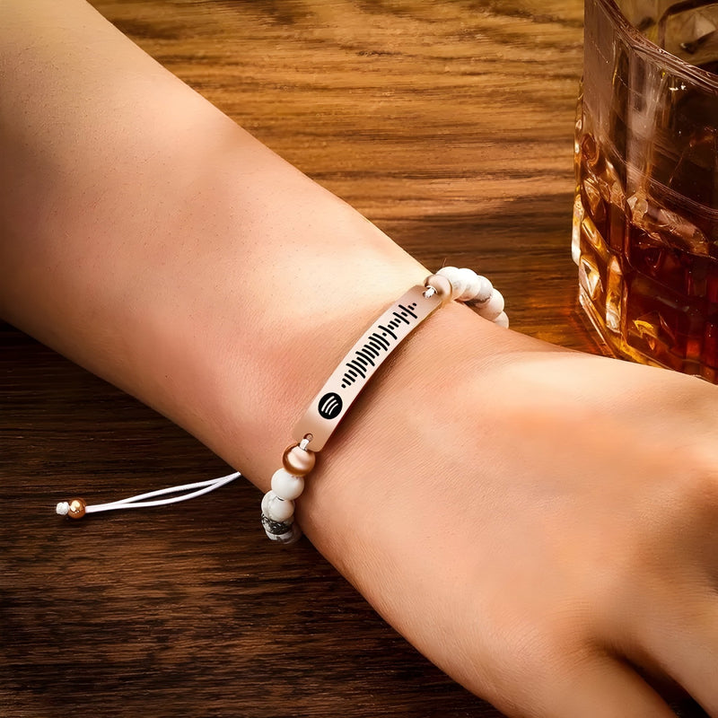 Bracelet personnalisé Spotify avec pierres naturelles blanches et plaque argentée gravée d'un code Spotify.