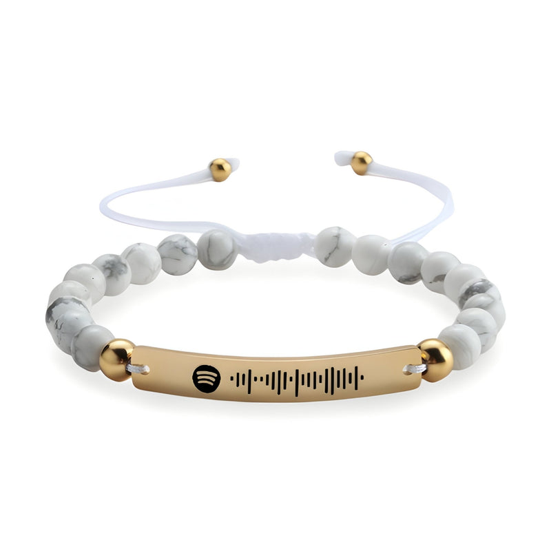 Bracelet personnalisé Spotify en pierres naturelles blanches avec plaque dorée rosée et cordon ajustable blanc.