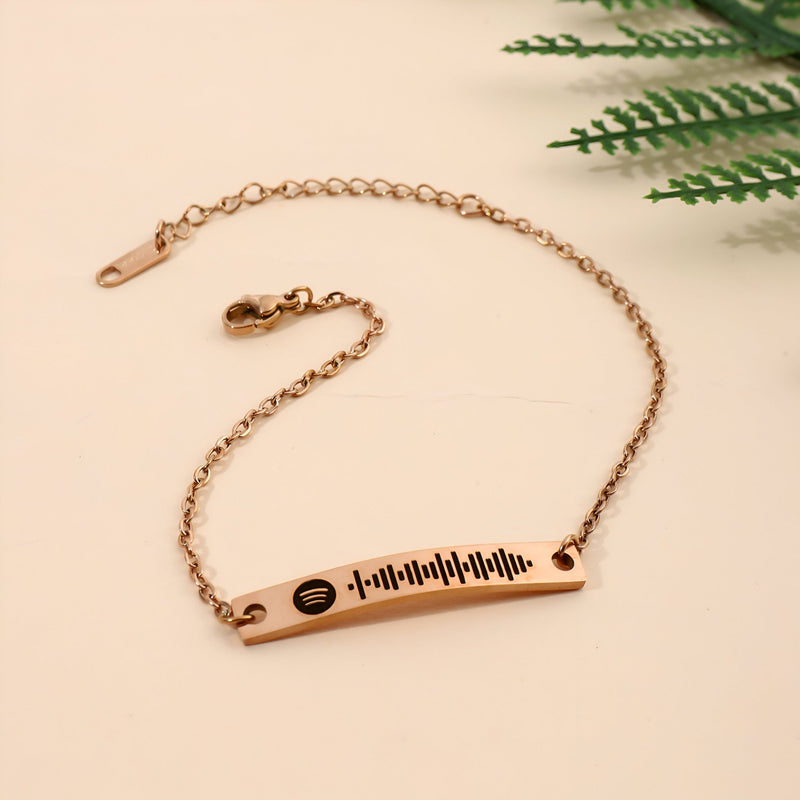Bracelet gourmette ajustable en or rosé avec plaque gravée code Spotify noir.